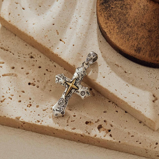 Oxidized sterling silver cross pendant with brass accent and engraved detail on travertine stone