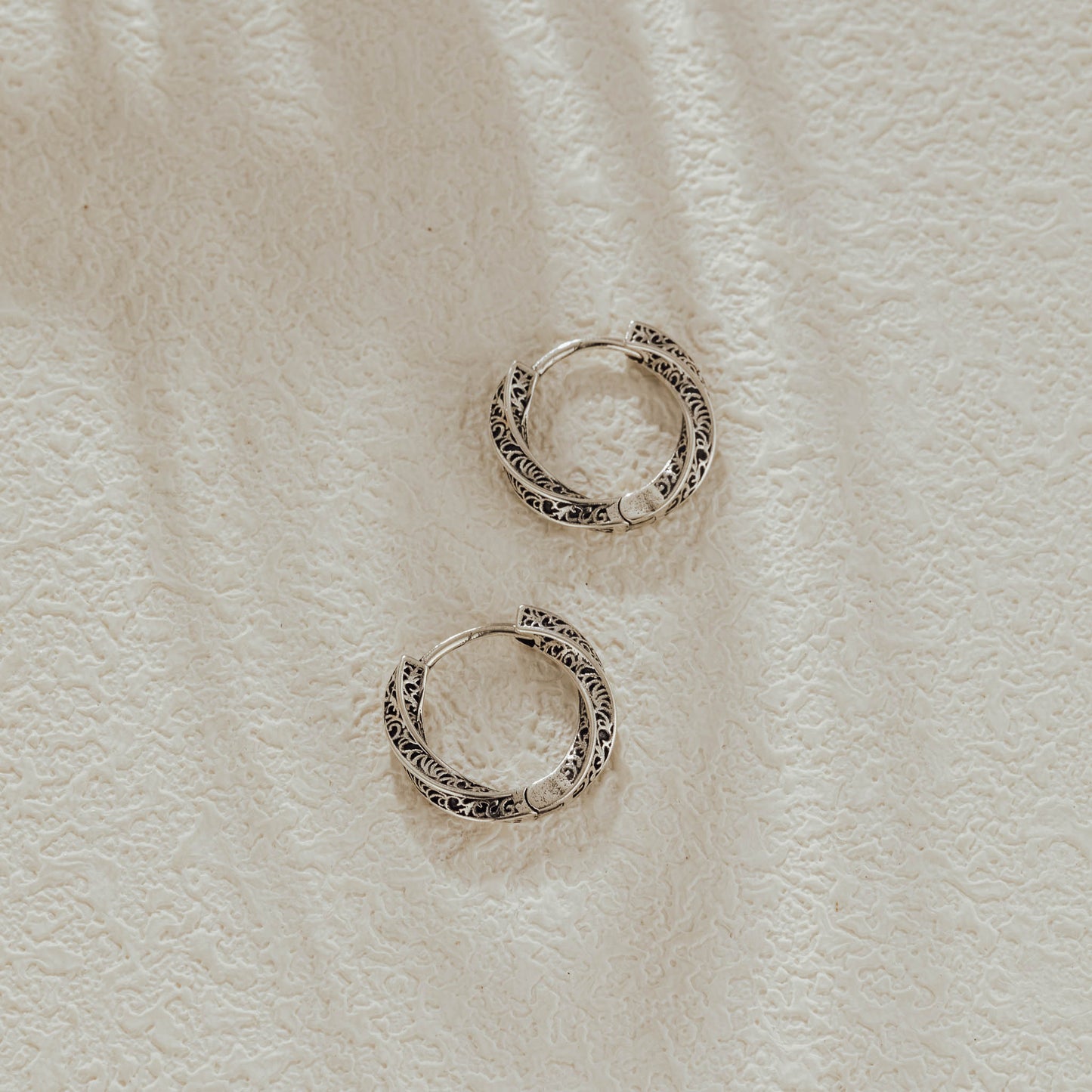 Small vintage silver huggie earrings with oxidized finish, top view
