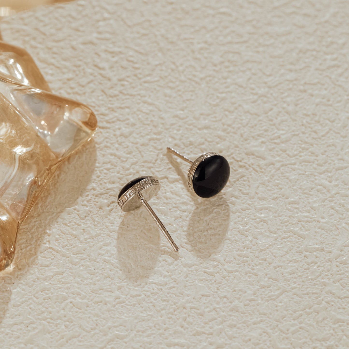 Side view showing engraved silver border on black CZ studs