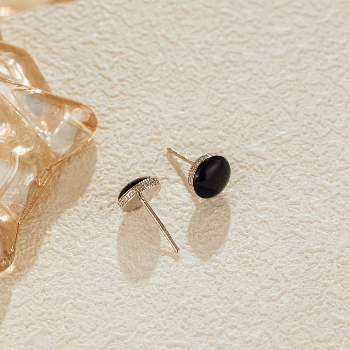 Side view showing engraved silver border on black CZ studs
