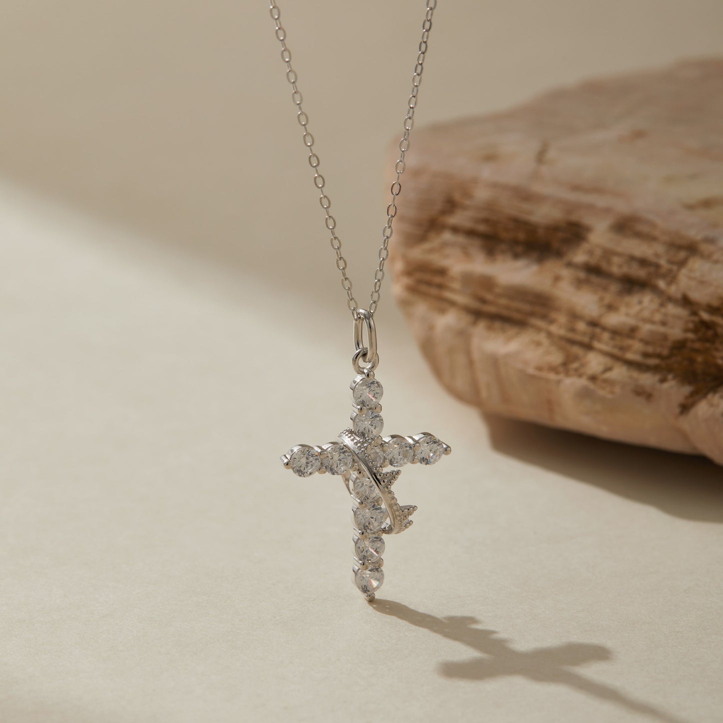Silver crown cross necklace showing sparkle under light