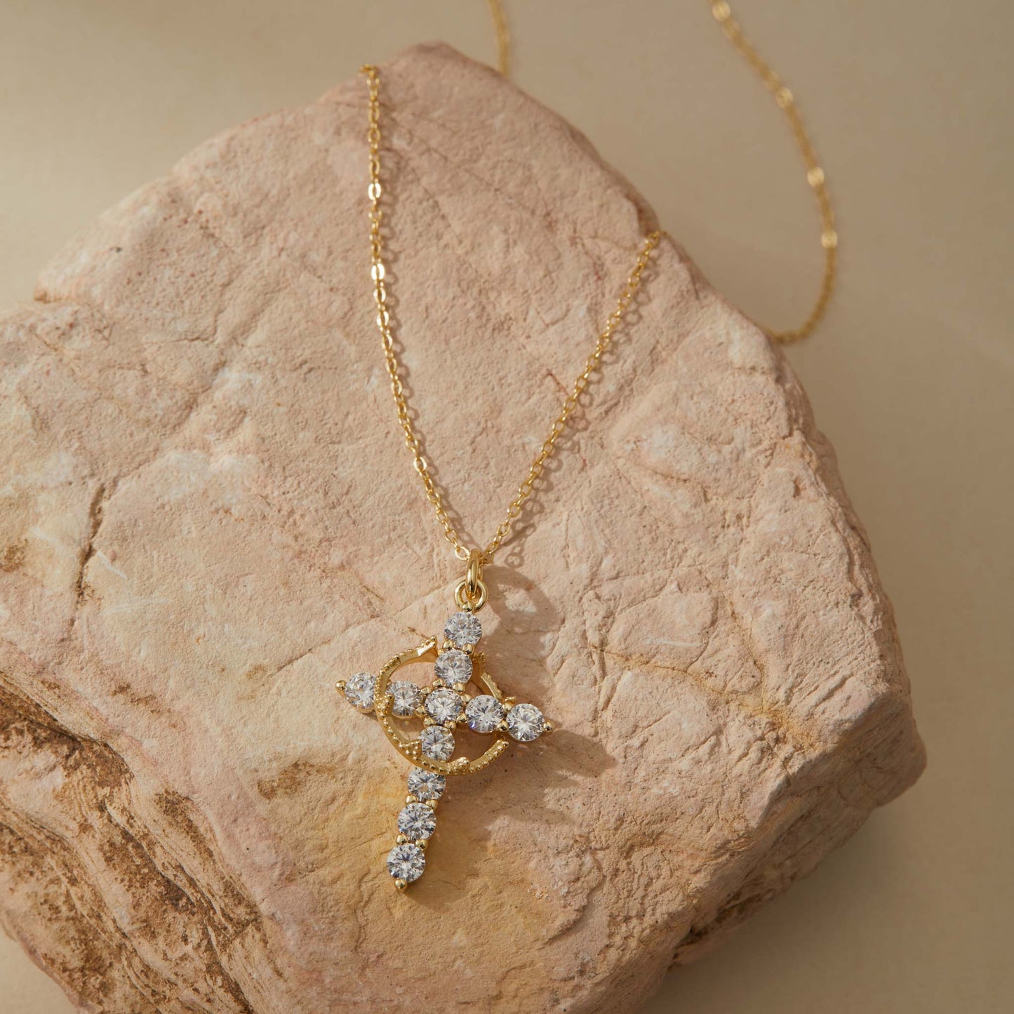 Gold rotatable cross pendant flat lay