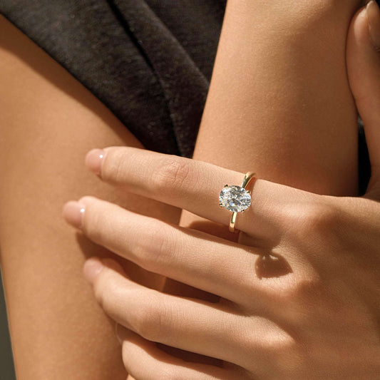 Adjustable 14K gold plated S925 sterling silver solitaire ring worn on hand in warm sunlight