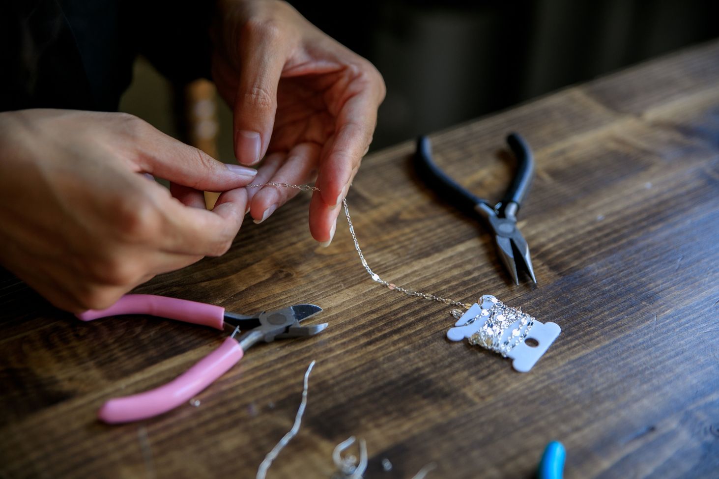 Close-up of hands handcrafting a 925 sterling silver chain with jewelry-making tools, showcasing Museori’s craftsmanship and attention to detail.