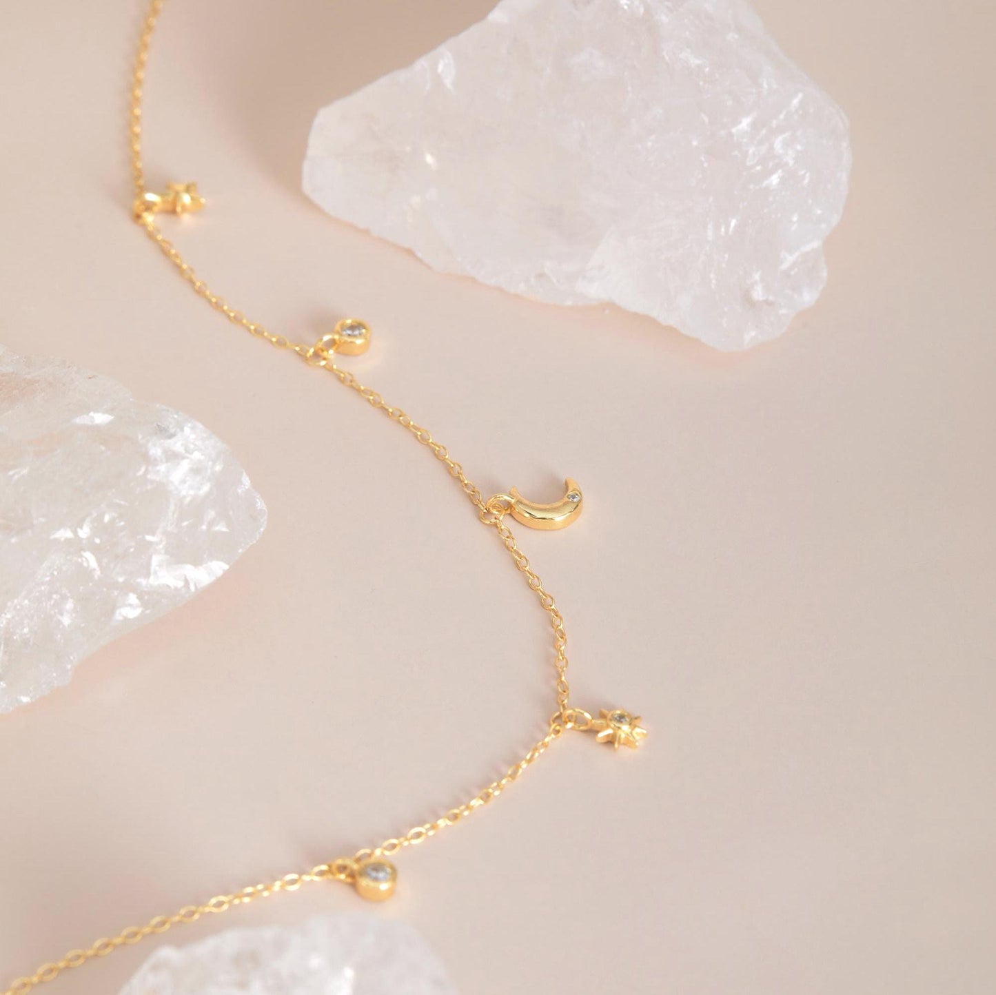 Gold macro detail — Moon & star charms with 5A CZ stones, dainty chain.