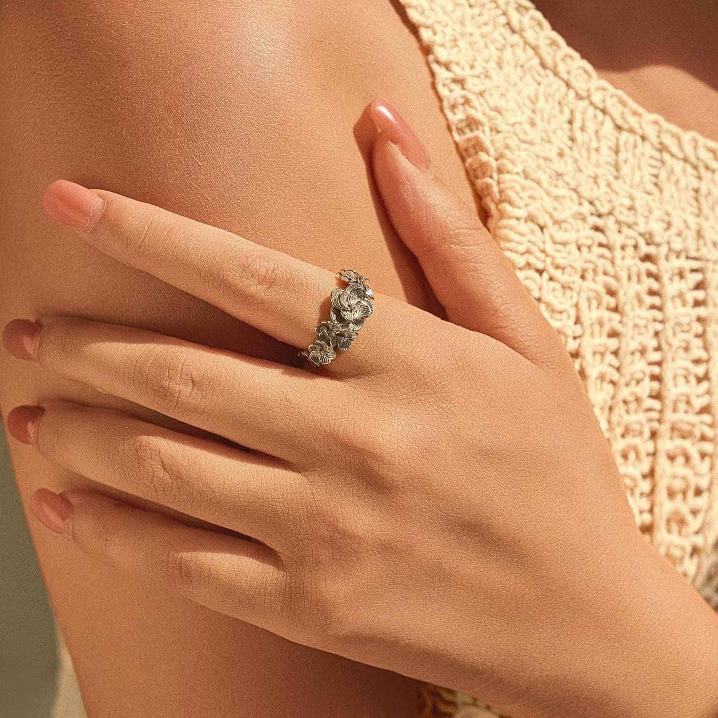 Floral sterling silver adjustable ring worn on hand