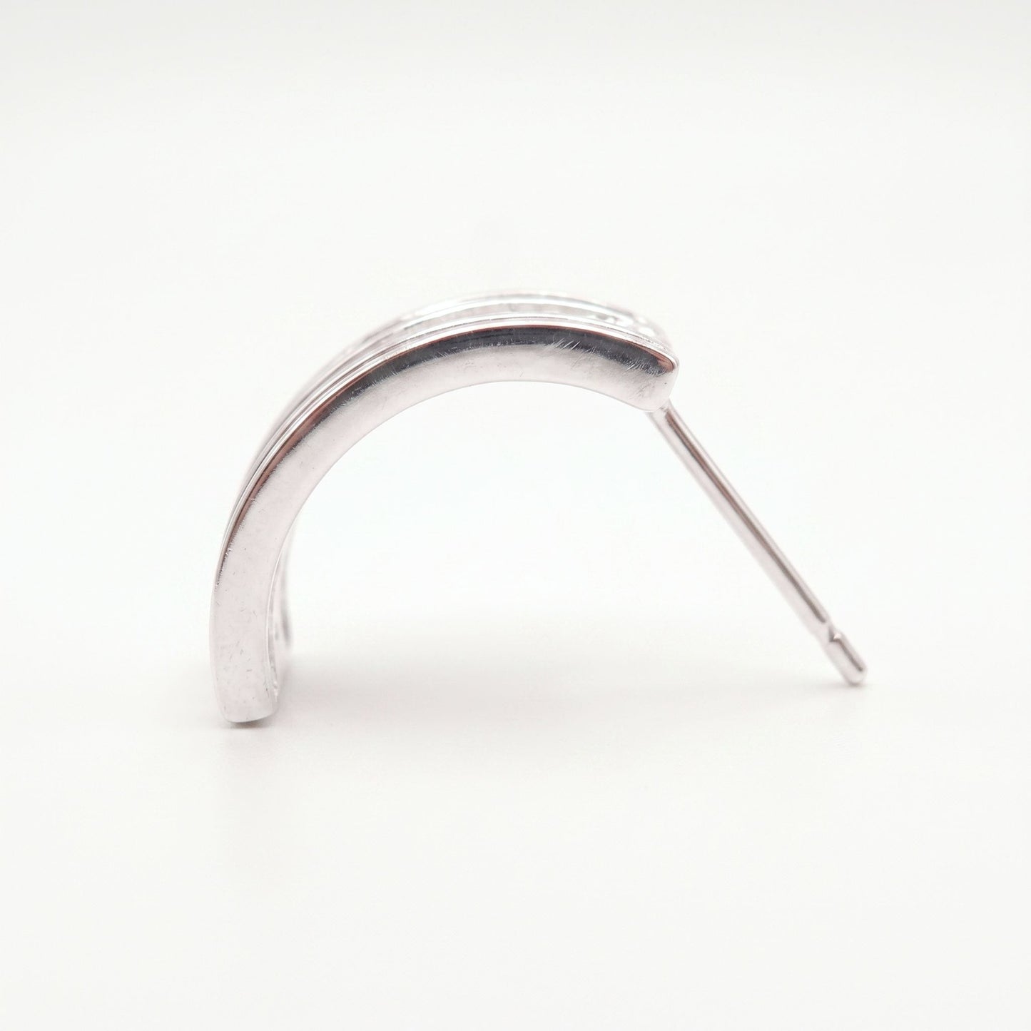 Side profile of a sterling silver half hoop earring showing the shallow arc and long post fitting