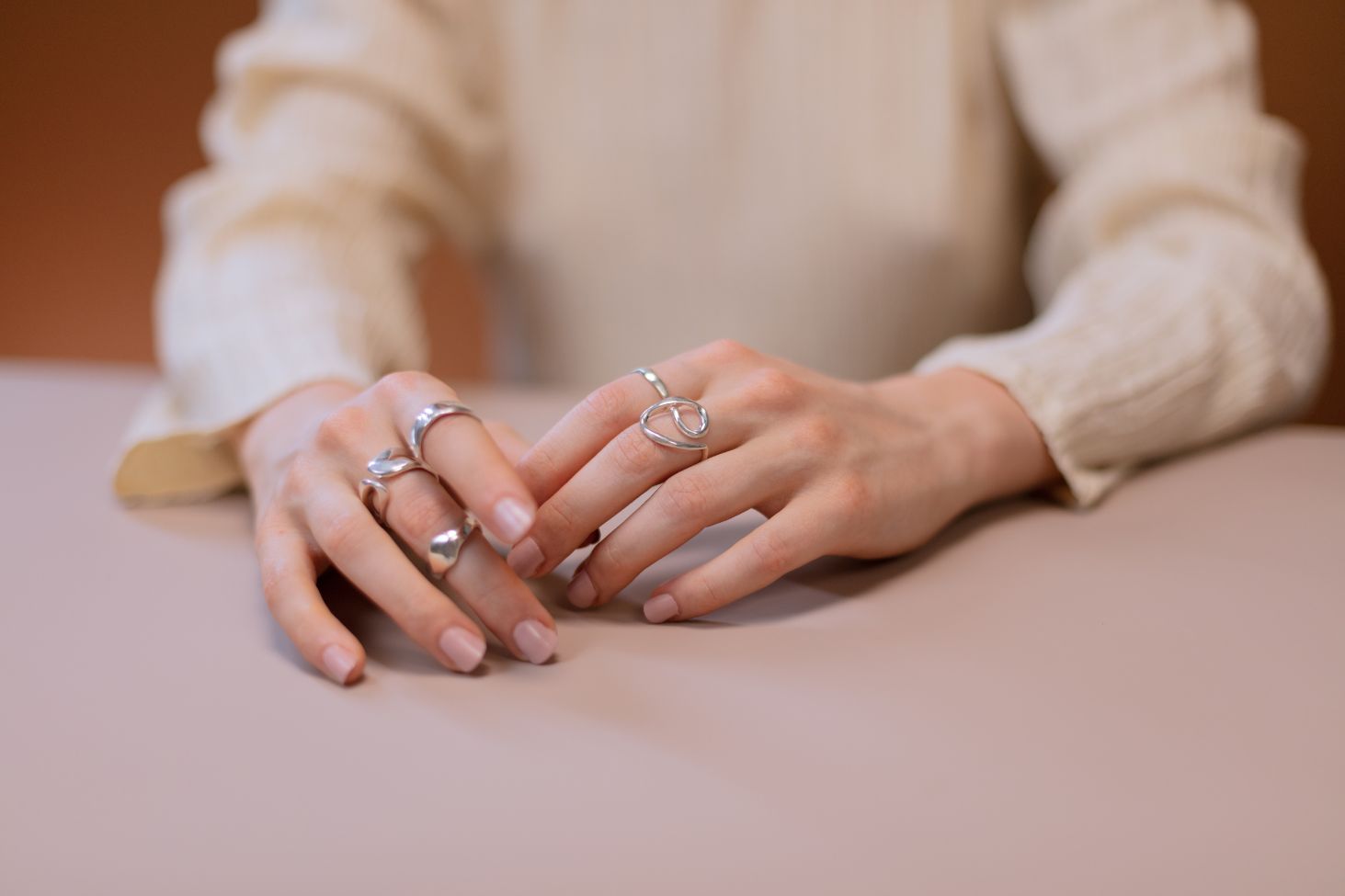 Close-up of hands wearing multiple 925 sterling silver rings from Museori, showcasing timeless and modern everyday jewelry.