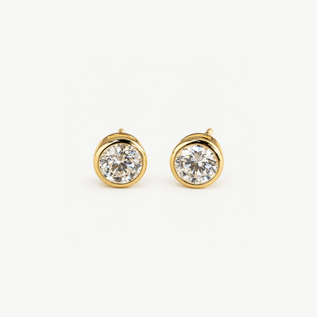 Front view of 1 ct round moissanite stud earrings set in polished 14k gold plated bezels, side by side