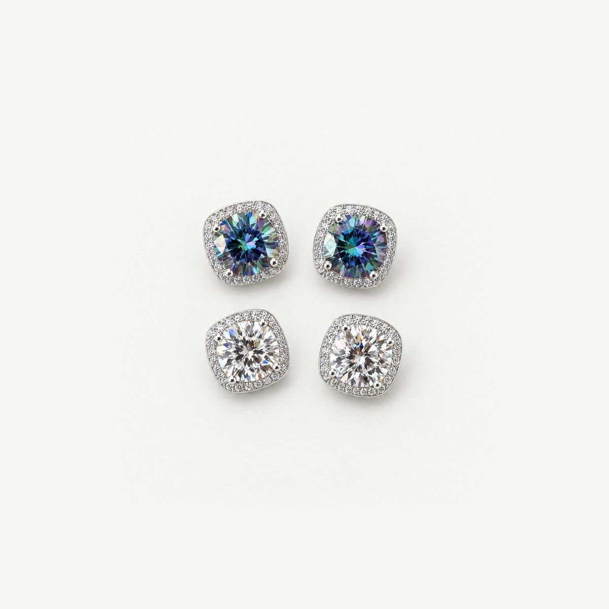 Two pairs of 1ct round moissanite halo stud earrings in sterling silver, rainbow blue and white, top view