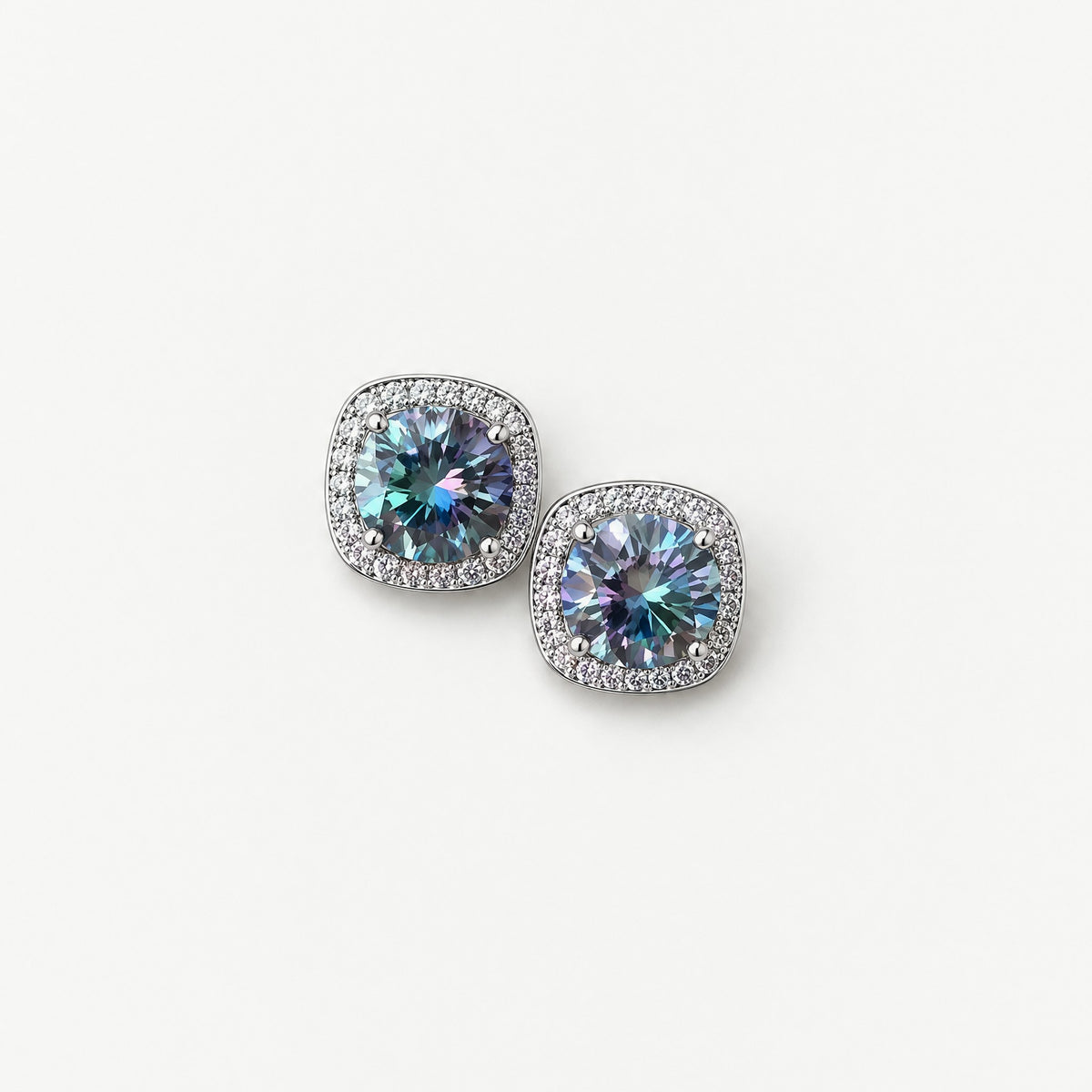 Pair of rainbow blue 1ct round moissanite studs with cushion-shaped pavé halos in sterling silver, from above