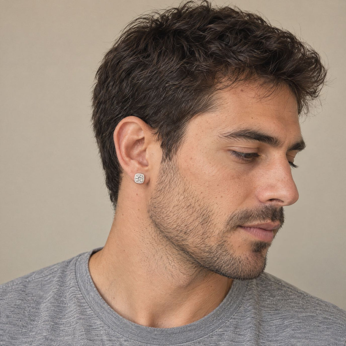 Man wearing a white 1ct moissanite halo stud earring in sterling silver, side view showing its size on the ear