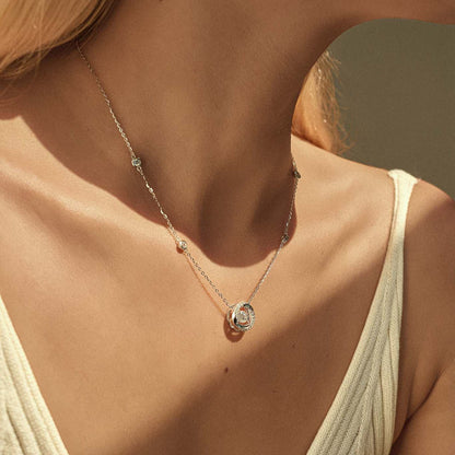 Woman wearing moissanite dancing stone spiral necklace, station chain on collarbone