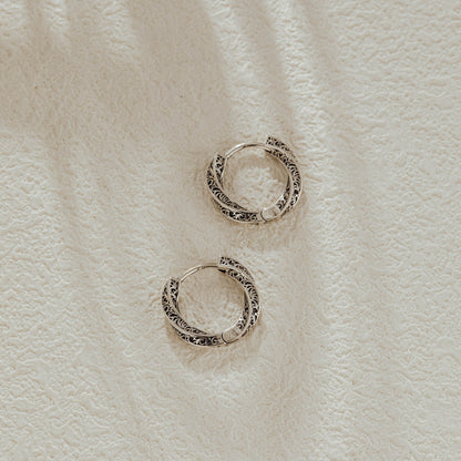 Small vintage silver huggie earrings with oxidized finish, top view