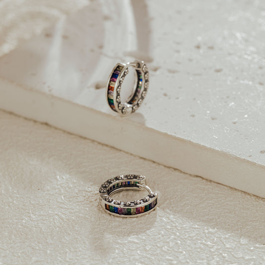 Sterling silver rainbow baguette huggie earrings on display card