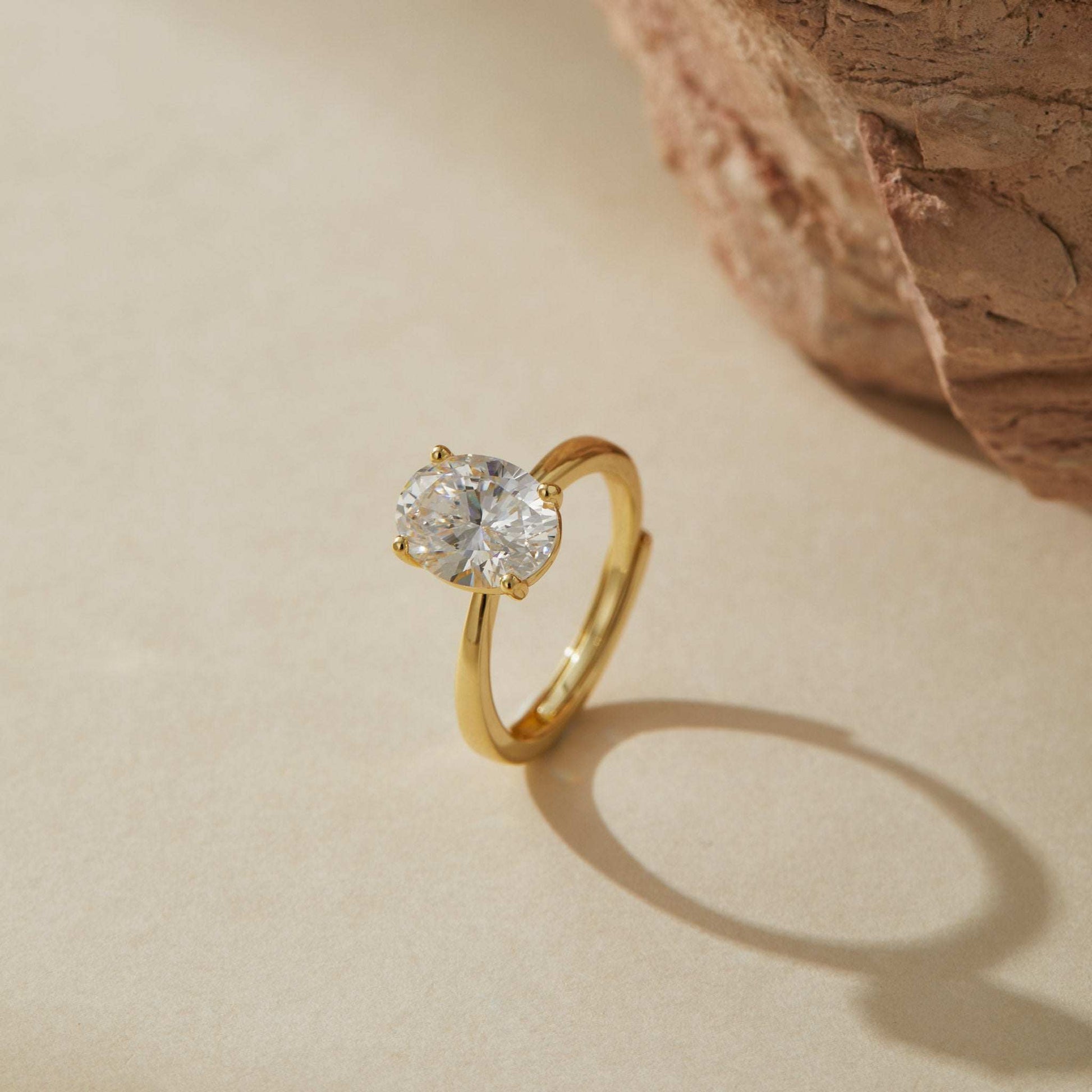 Minimalist adjustable gold plated sterling silver ring with oval cubic zirconia in soft light