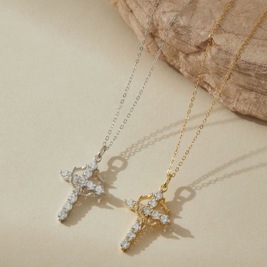Gold and silver rotatable crown cross necklaces on neutral background