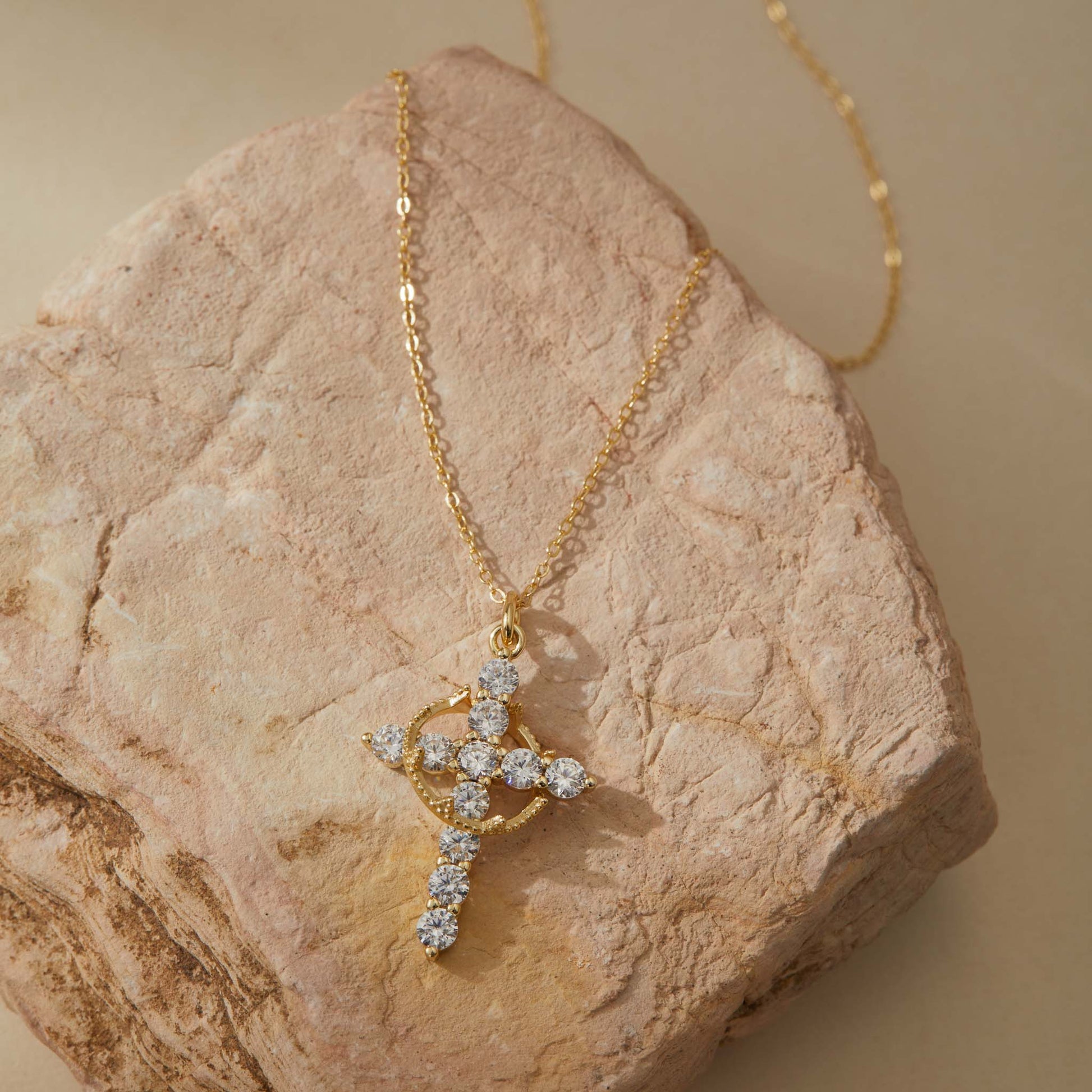 Gold rotatable cross pendant flat lay