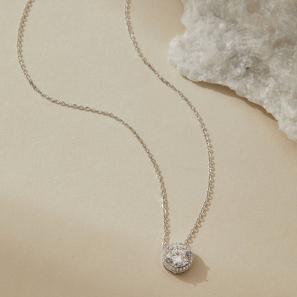 Sterling silver moissanite halo pendant necklace with quartz crystal in background

