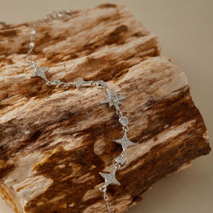 Close-up of cubic zirconia star charms on silver bracelet