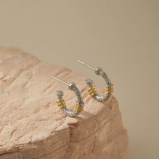 Two-tone silver and gold hoop earrings, detailed engraving close-up