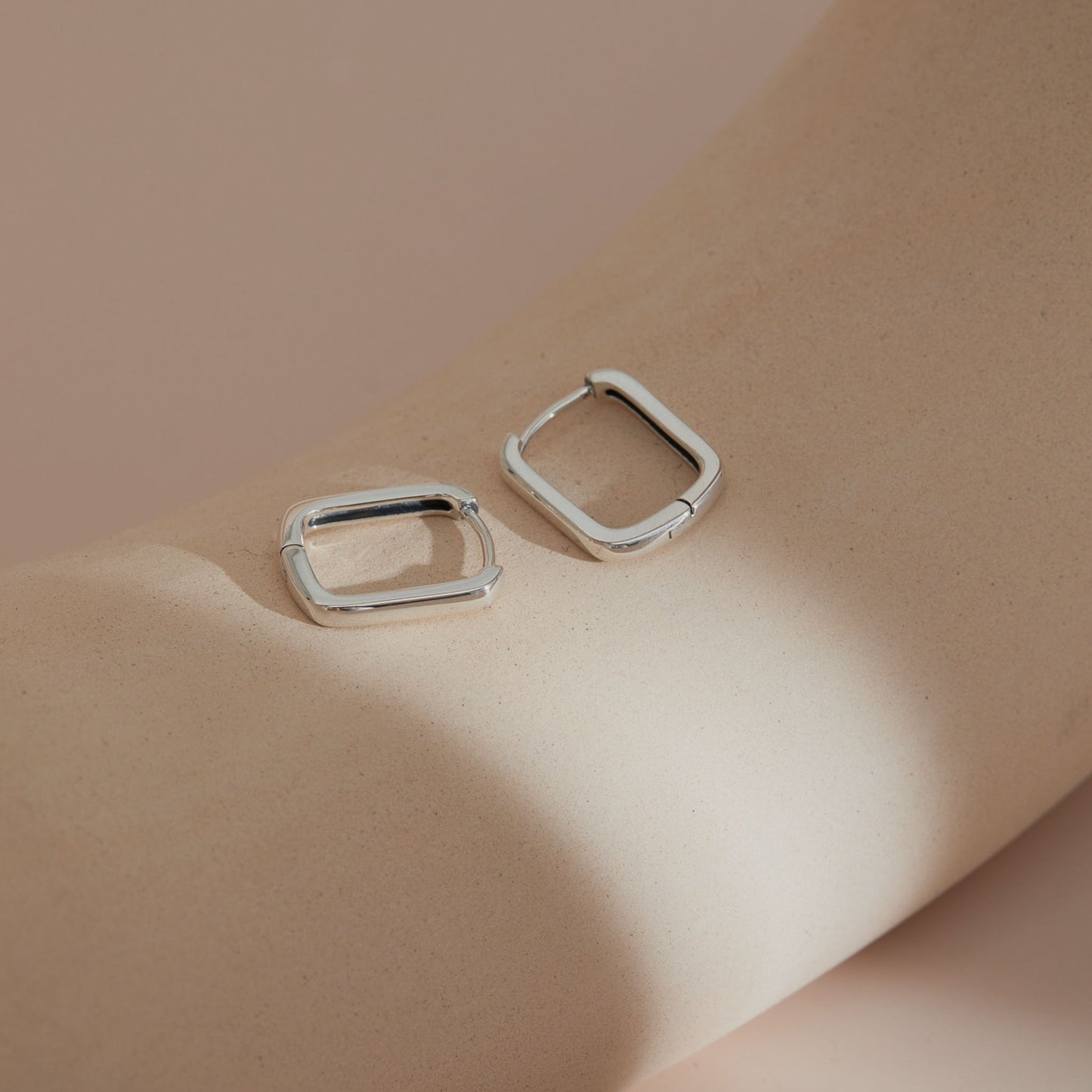Rectangular S925 huggie earrings capturing natural light