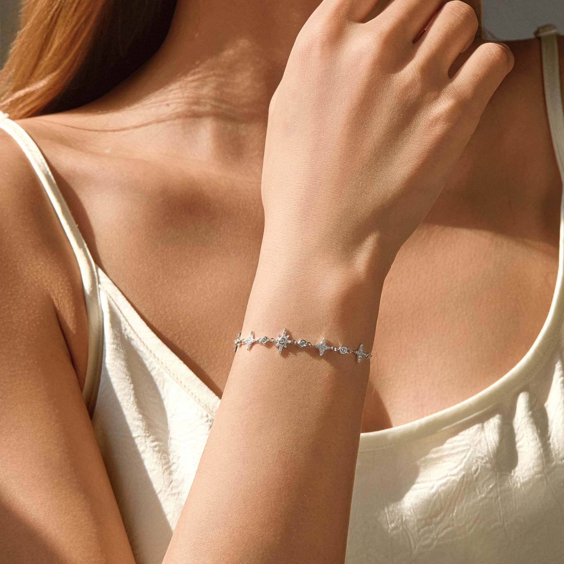 Model wearing dainty starry silver bracelet on wrist