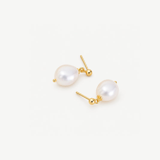 Gold plated baroque freshwater pearl drop earrings lying head to toe on a white background, posts and ball studs showing