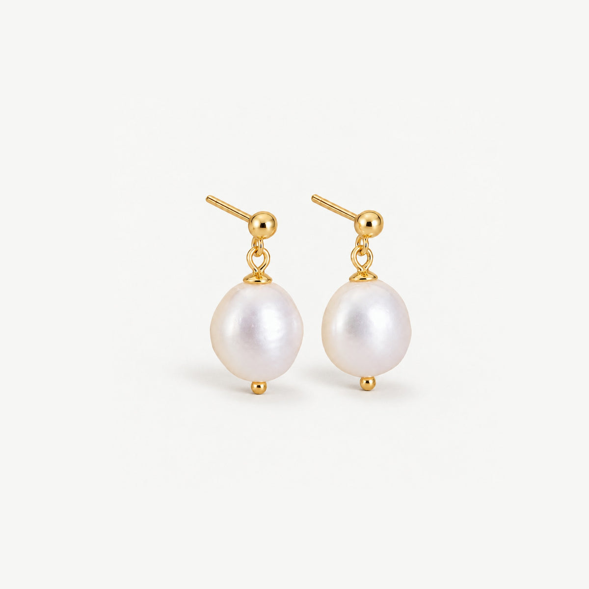 Front view of a pair of baroque freshwater pearl drop earrings on gold plated ball studs against a white background