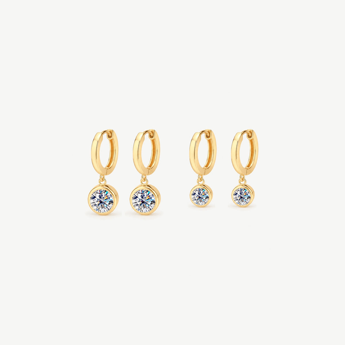 Two pairs of gold drop huggie earrings on the same 12 mm hoop, one pair with 1 ct and one with 0.5 ct moissanite