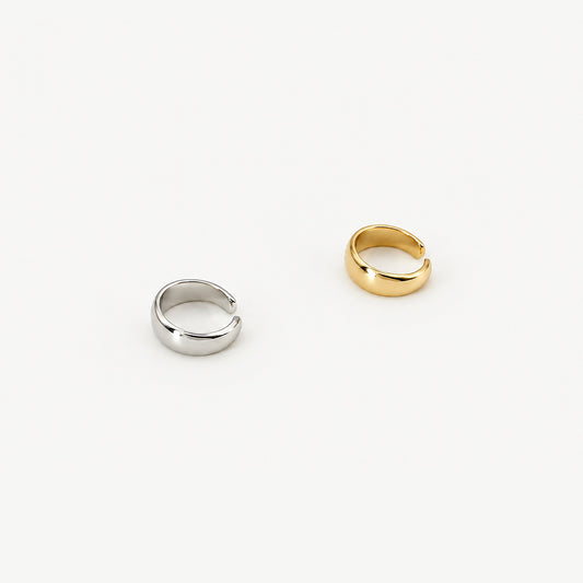 Two dome ear cuffs side by side, one in sterling silver and one gold-plated, polished open bands