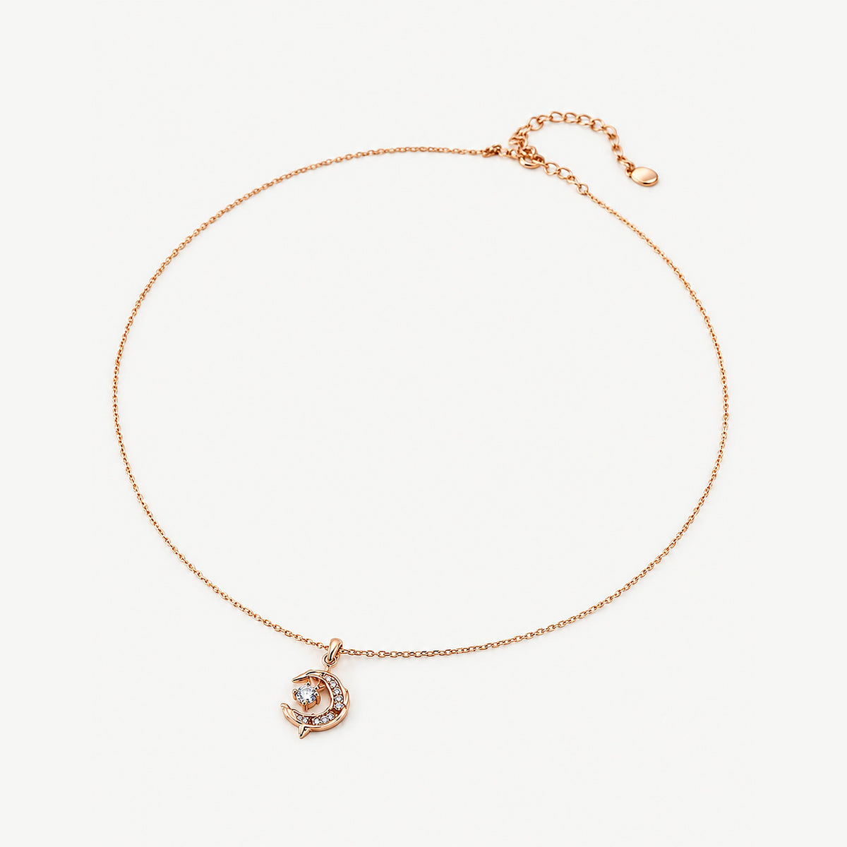 18k gold-plated sterling silver crescent moon necklace laid flat, dolphin pendant with clear stones and extender chain