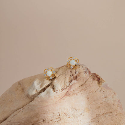 Gold opal floral stud earrings styled on textured stone for a warm, natural look