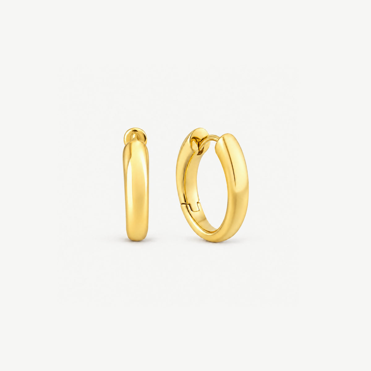 Pair of tapered gold-plated sterling silver huggie hoops, one face-on, one turned to show the hinge and inside
