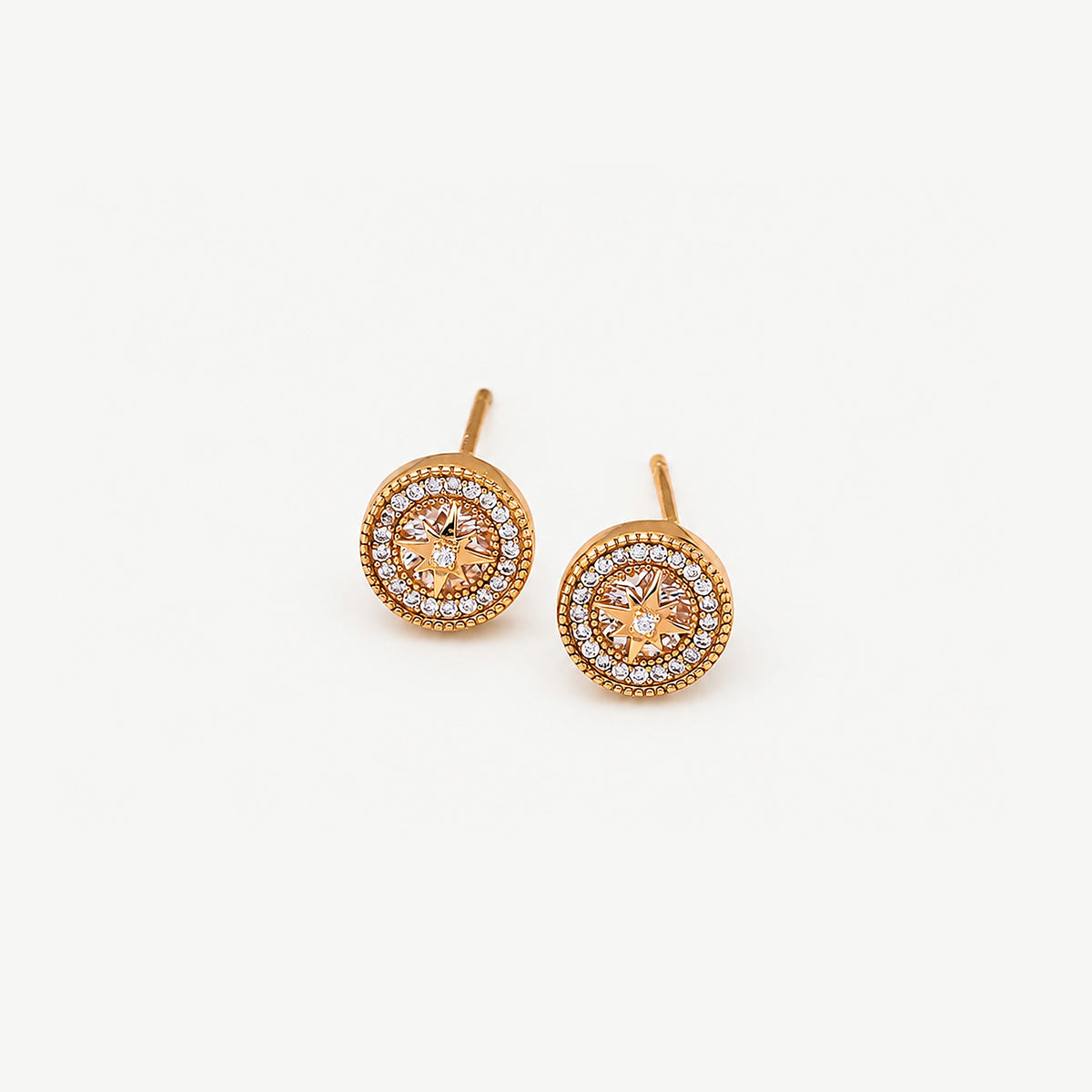 Pair of gold-plated sterling silver starburst halo studs, posts upright, an eight-point star over a faceted stone