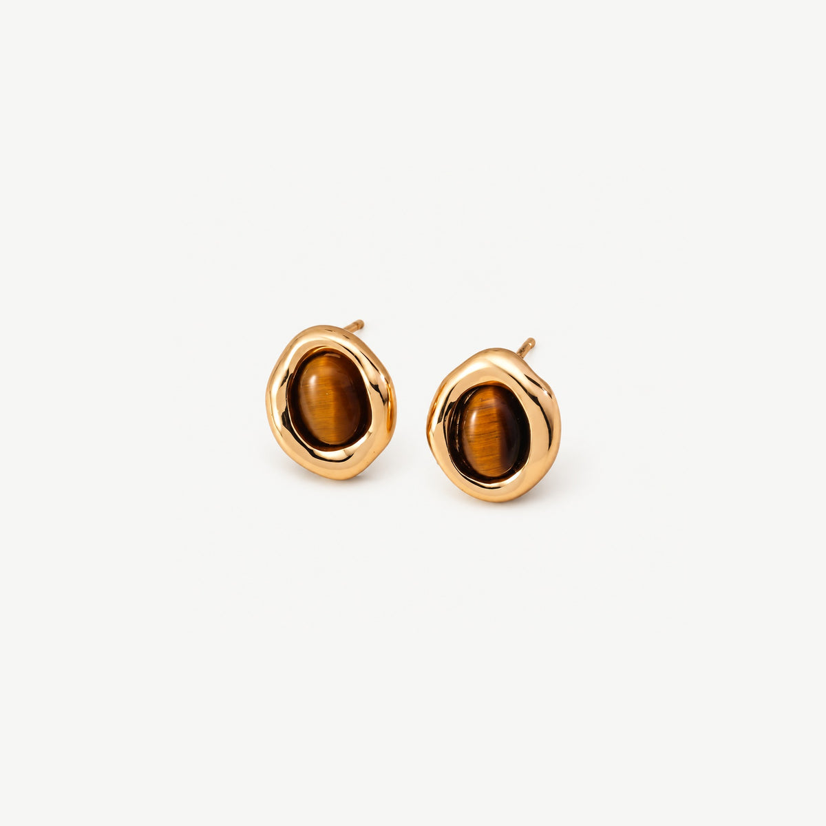 Gold-plated tiger eye stud earrings at an angle, showing the softly uneven frame, honey-brown stones and straight posts