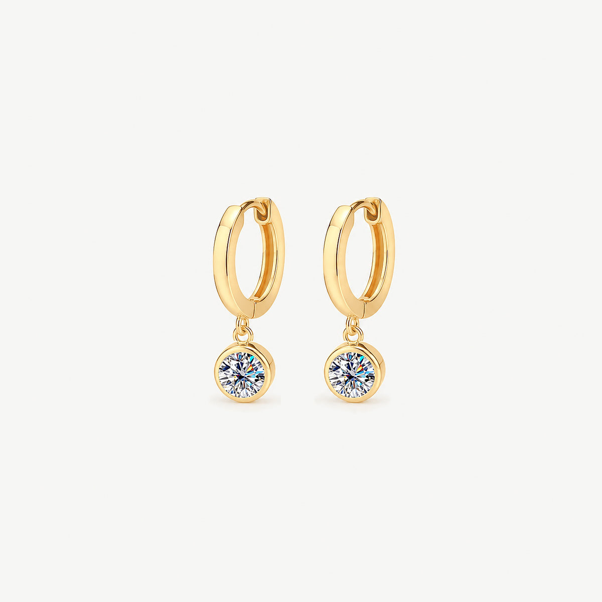 Pair of 14k gold plated huggie hoop earrings with smaller 0.5 ct round moissanite drops in smooth bezels, front view