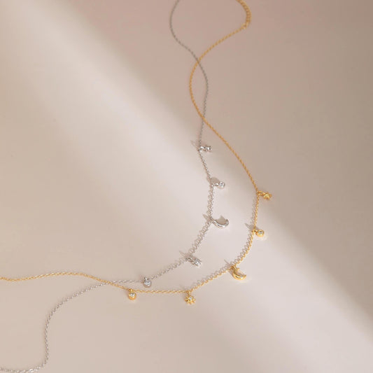 Gold & silver flat lay — Celestial Sparkle Necklaces with moon & star charms, adjustable chain.
