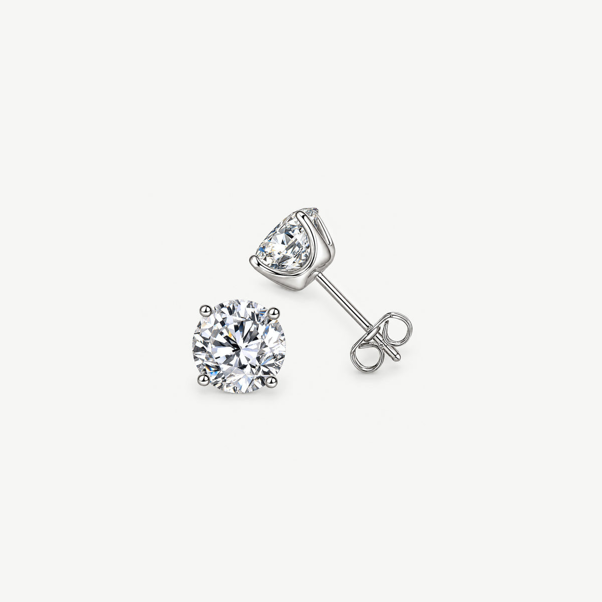 Sterling silver moissanite stud earrings on near white, one face on, one on its side showing four prongs, post and back
