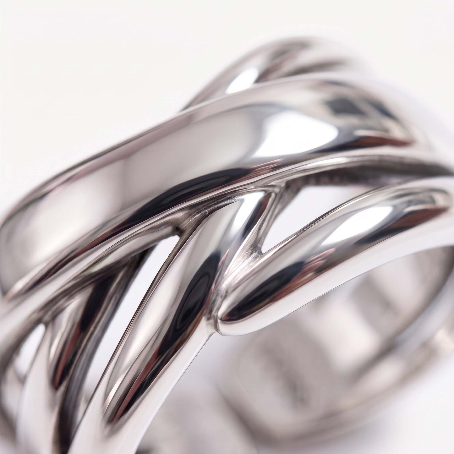 Close-up of a sterling silver crossover ring showing polished bands crossing over each other