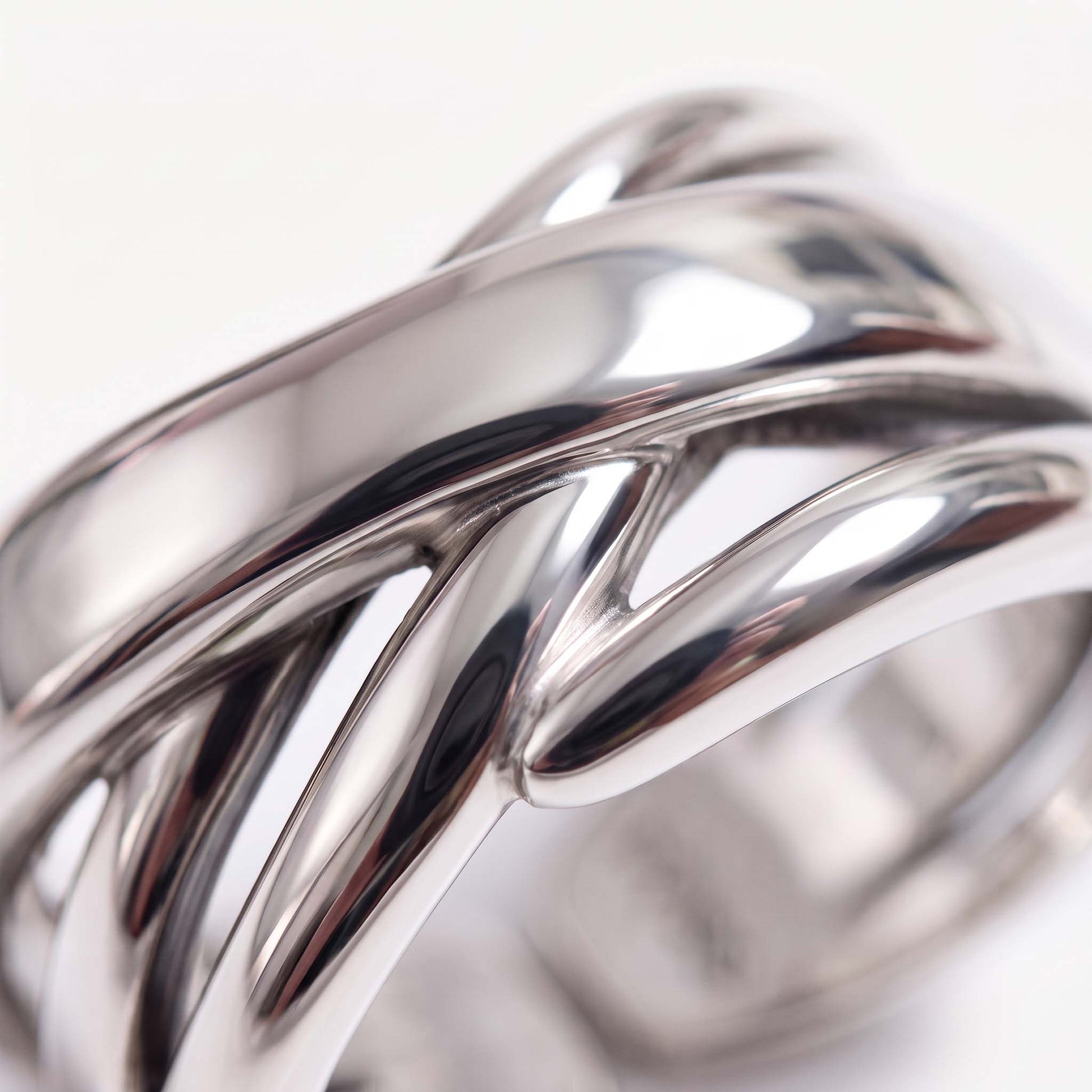 Close-up of a sterling silver crossover ring showing polished bands crossing over each other