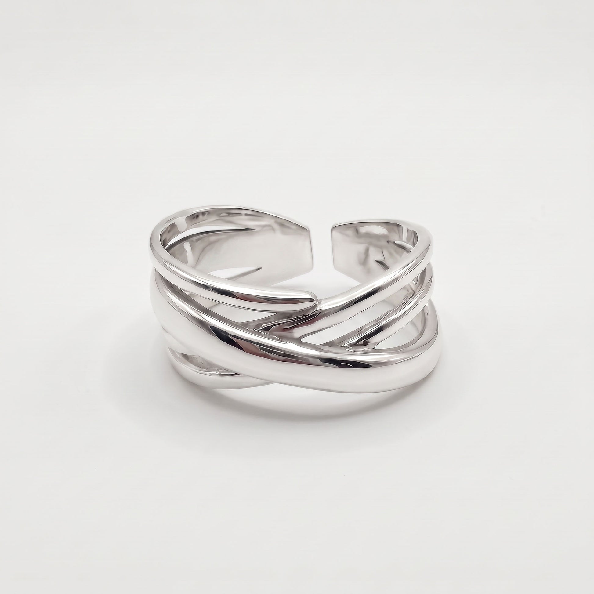 Sterling silver crossover ring with polished bands crossing over a wide open adjustable band