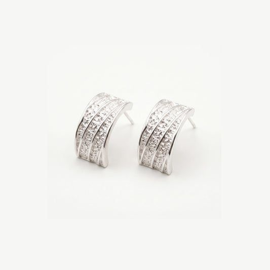 Pair of chunky sterling silver hammered half hoop earrings with polished ribs, shown on a plain white background