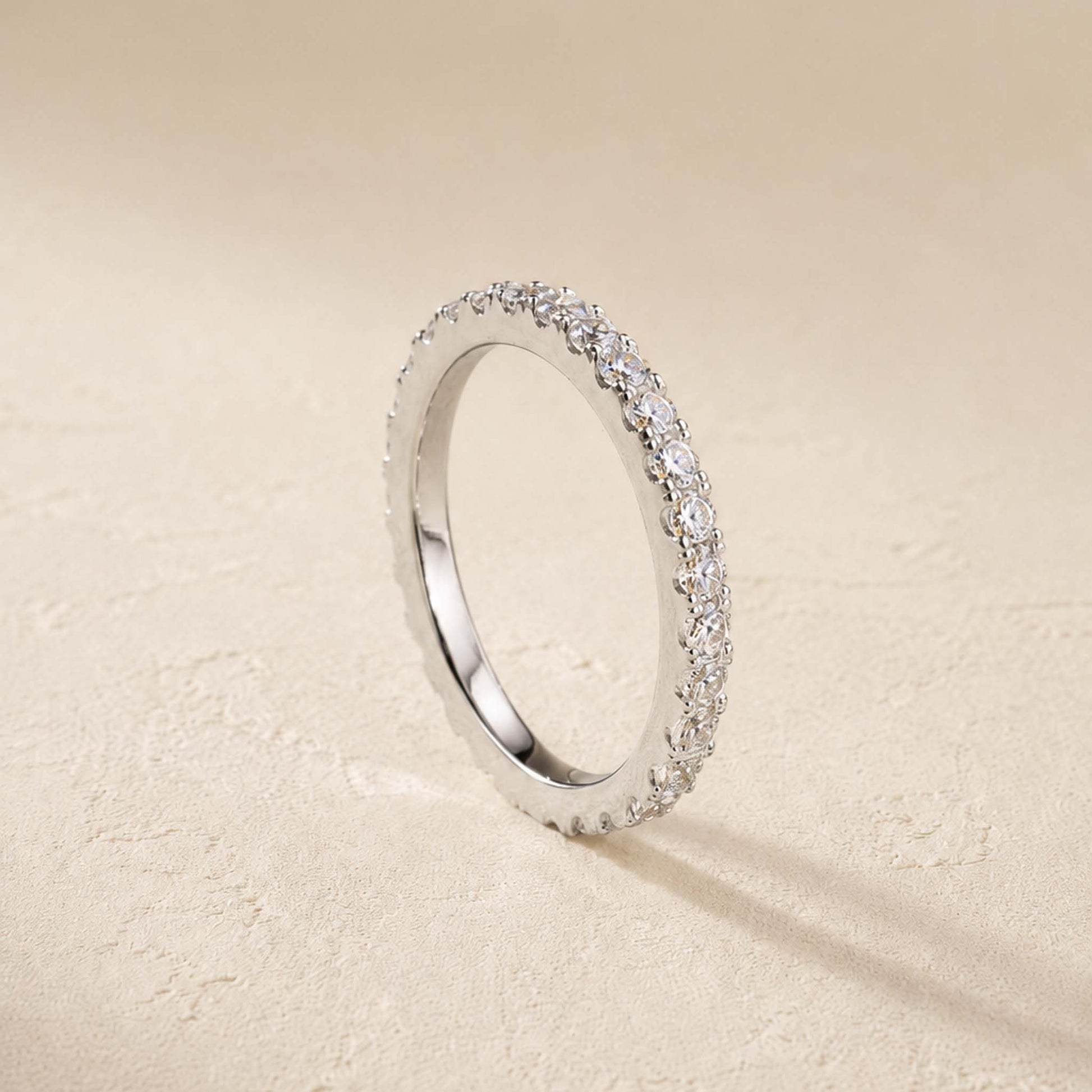 Side view of sterling silver moissanite eternity ring showing pavé-set stones around a slim 2mm band
