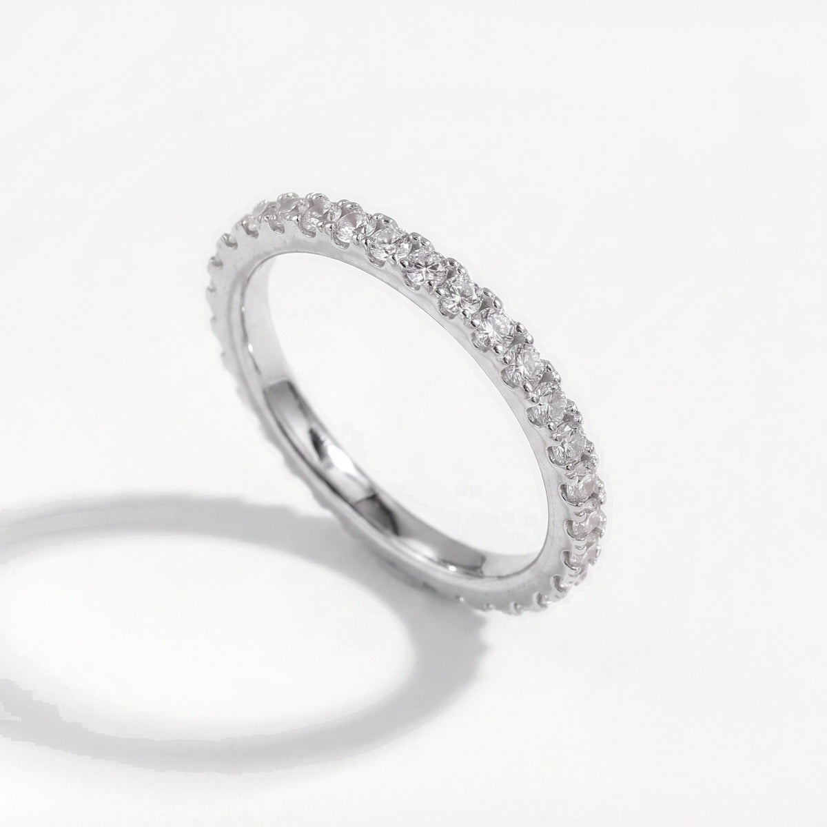 Moissanite full pavé eternity ring in sterling silver standing upright, round cut stones around the band