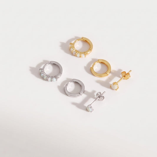 Gold plated and sterling silver opal earring sets of three shown together on a plain near-white background