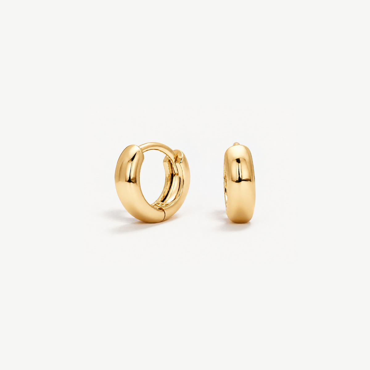 Pair of 7 mm gold plated dome huggie hoop earrings, one facing front to show the hinged snap, one in side view