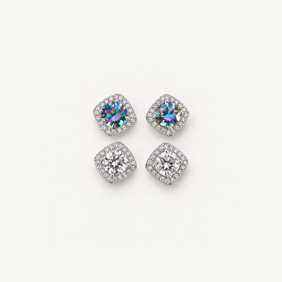 Two pairs of 0.5ct moissanite halo stud earrings in sterling silver, rainbow blue and colorless, on off-white