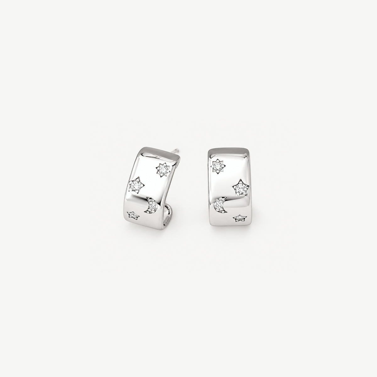 Front view of sterling silver chunky half hoop earrings, a wide polished band set with stars and a crescent moon