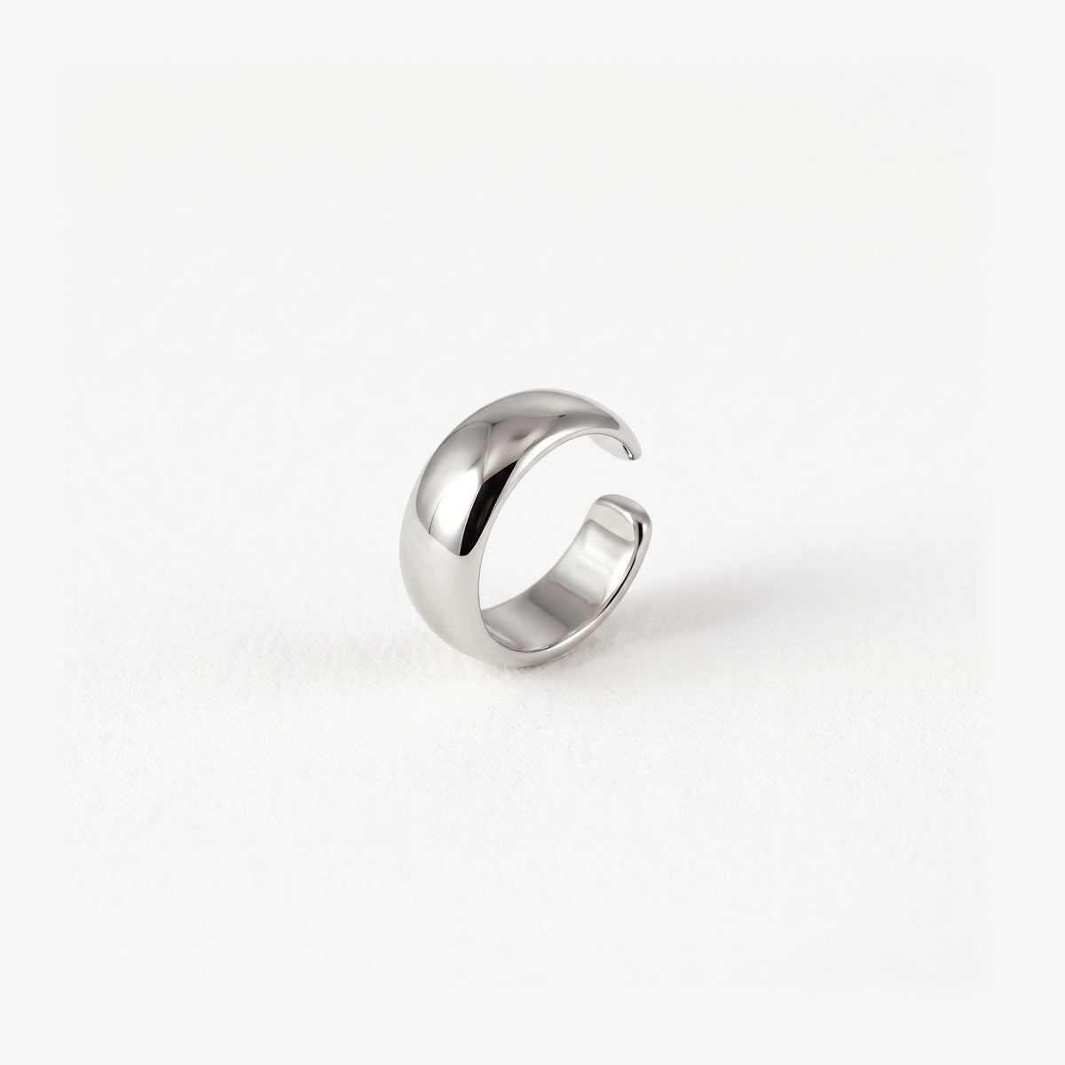 Sterling silver dome ear cuff standing upright, polished band tapering to two fine open ends